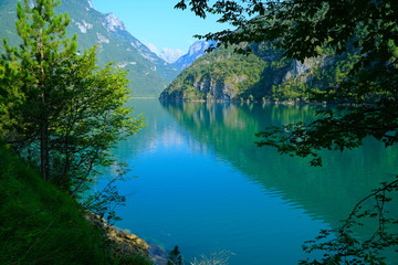 The Lago del Mis is lake in Belluno, Veneto, Italy,  looks very beautiful with its green colors. It's morning and sunrise. Beautiful italian nature. The Dolomites are a mountain range located in Italy