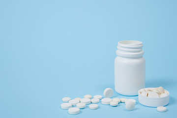 White medical pills on blue background.