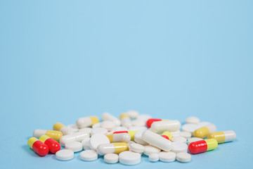 Pills are scattered over a blue background