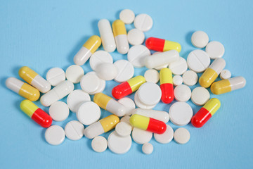 Pills are scattered over a blue background