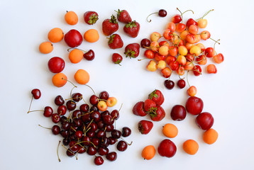 Strawberries, cherries, cherries, plums, cherry plums lie on a white background