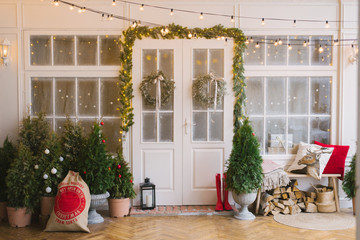 The white private house is decorated with small Christmas trees and lanterns, a bag of gifts. A...
