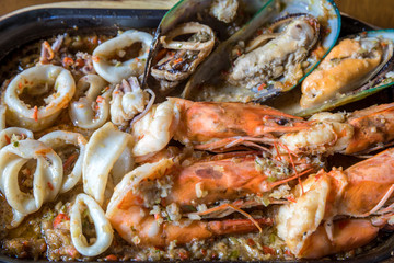 Seafood salad with prawns, mussels and squids. Fried stir spicy sea food in hot pan. 