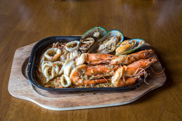 Seafood salad with prawns, mussels and squids. Fried stir spicy sea food in hot pan. 
