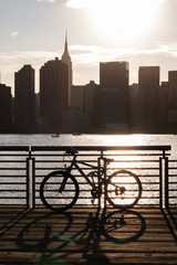 Plakat Bicycle on a Railing along the East River at Gantry Plaza State Park in Long Island City Queens during a Sunset with the Manhattan Skyline