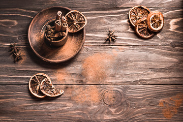 Cinnamon sticks, star anise and pieces of orange rustic wood board background. A set of spices for mulled wine. Copy space, top view