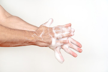 Fototapeta premium A man washes his hands with soap on a white background. Global handwashing day