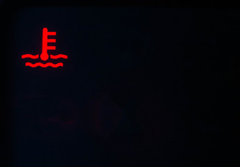 Red indicator of car engine coolant on a black background. Car overheating concept, copy space for text