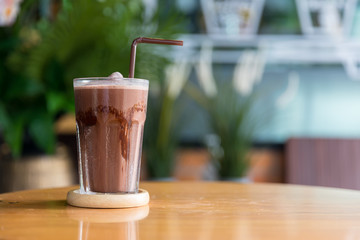 A glass of iced chocolate on table. A glass of Iced Cocoa cool drink served on table. Iced cocoa...