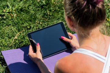 A close up girl holds a tablet lying on her stomach looking top. Online training by video conference over the internet