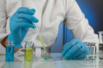 scientist's hands in gloves are conducting chemical experiments in lab close up