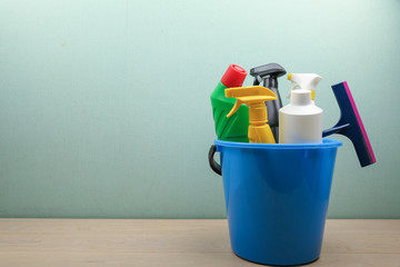 bucket with cleaning products on blue background