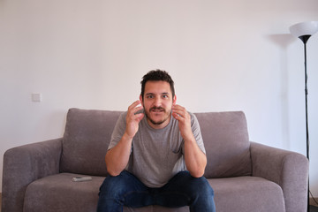 Portrait of a excited young man sitting on a sofa watching his sport team, which is about to score points.