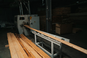 Pine sawn timber processed in a construction workshop. Concept of folded stacked timber.