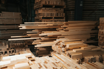 Pine sawn timber processed in a construction workshop. Concept of folded stacked timber.