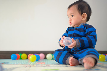 Obraz premium Kid playing with ball on soft carpet in children room