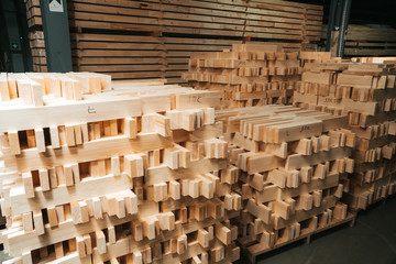 The lumber is ready to be sent to the loading workshop. A stack of new wooden planks lying in a small warehouse