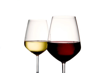 Foreground of two glasses of wine, the first is a glass of red wine, the second is a glass of white wine on a light background