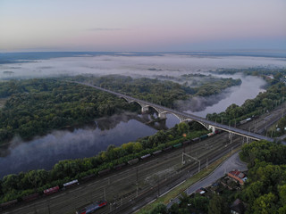 Bridge over the Klyazma river and railway in Vladimir. Taken from a drone at dawn.  Foggy and sunrise.