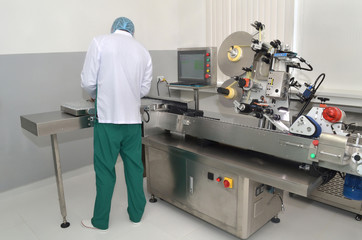 Naklejka premium Pharmaceutical industry worker install the ampules on the labeling machine
