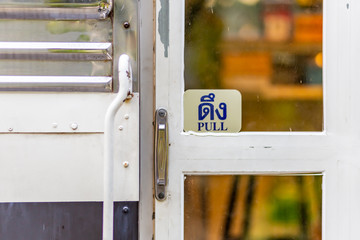 Pull symbol at the white door.