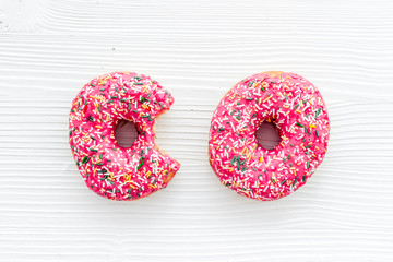 Donuts flat lay pattern on white wooden background, top view