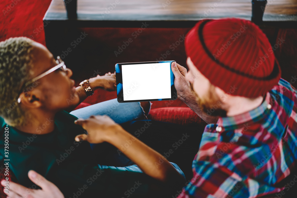 Aufkleber back view of couple watching online movie on blank touch pad using home internet for wireless browsi