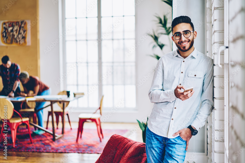 Aufkleber half length portrait of cheerful millennial hipster guy in optical eyewear using cellular applicatio