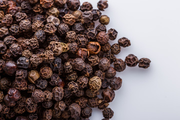 fragrant black pepper on white acrylic background