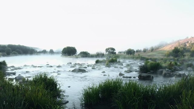 Beautiful River rapids in the fog in the morning. River water landscape. Flying from the drone through the morning fog over the river. Beautiful landscape. Forest river flow.