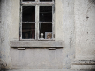 A portrait of Lenin and a bust of Dzerzhinsky outside the window of the apartment.