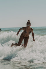 Fototapeta premium Chica joven y guapa surfeando por playas de Cadiz
