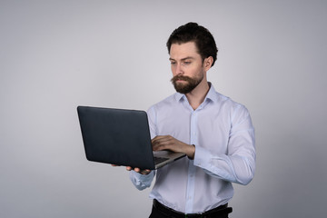 Portrait of man, working on laptop in casuals - isolated on white. Concept communication.