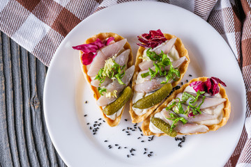 delicious snack tartlets on rustic wooden background