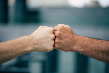 Close up outdoor photo of two men's fists holding together