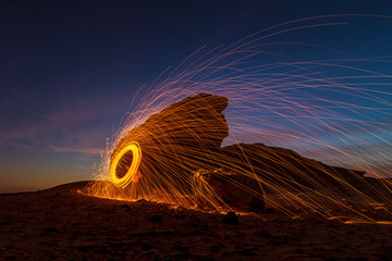 A steel wool on fire at night (night photography using a slow shutter speed) - selective focused on...