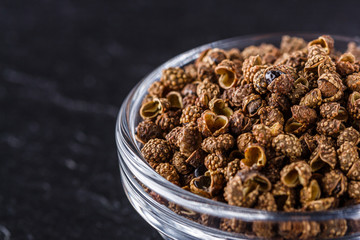 Sichuan pepper on a dark stone background