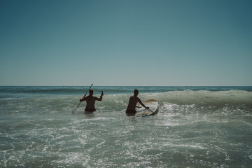 Jovenes en la playa con una tabla de padel surf