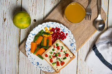 Fototapeta na wymiar Boiled vegetables, pomegranate seeds, fruit, fruit juice and bread on a wooden platter