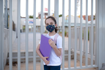 Girl at the door of the school with mask