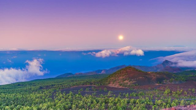 Timelapse of the moon falling behind the horizon during sunrise in the volcanic mountains of the island of Tenerife, Canary Islands, Spain.