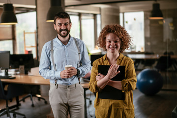 Businesswoman and businessman discussing work in office. Two friends in working together..