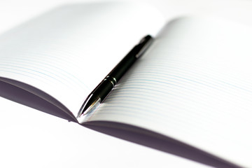 Top view of opened notepad with black pen white background. Mockup for your banner. Flat lay.