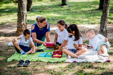 School children in white t shirt eating lunch during their lunch break at school