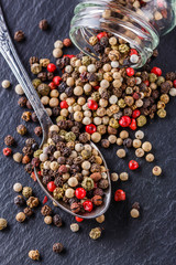mix of peppercorns on a dark stone background