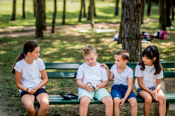 School boy with diabetes testing his blood sugar after physical education, friends support him.