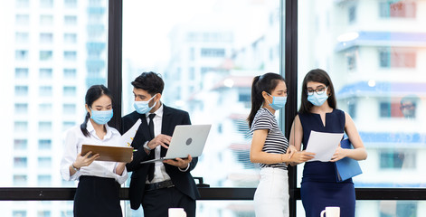 Young businesswoman and business man wearing protective face mask while meeting for making new...