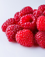 Juicy fresh natural raspberries on white acrylic background