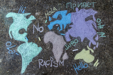 World map painted on the floor in the street with colored chalks with words "no racism"