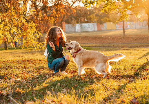 Happy sporty woman rest with her dog golden retriever. Female athlete enjoying outdoor with her pet. woman is training outside during autumn